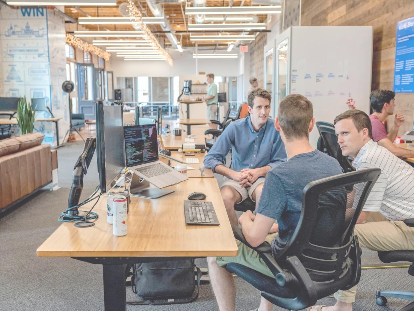 Developer analyzing mobile app performance metrics on multiple screens